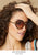 Model wearing tortoise colored sunglasses. Shop accessories.