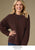 Model on brown background wearing fall brown sweater.