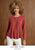 Model wearing bold bright fall top on brown textured background with promotional text featuring autumn tones collections.