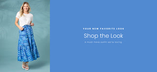 Model wearing white t-shirt and blue polka dot skirt on blue background. Shop the look.