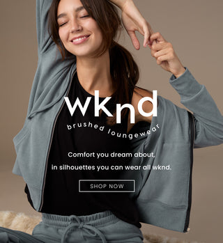 Woman wearing gray hoodie and pants with 'wknd' brand text on a beige background