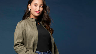 Model wearing green jacket on blue background.