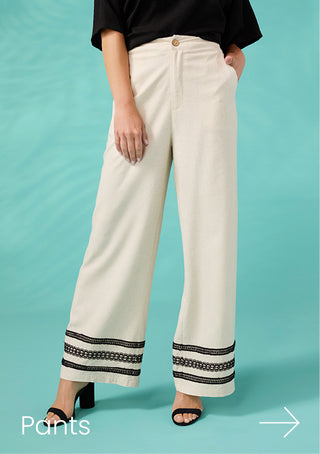 White pants with black trim worn by a person on a teal background