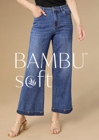 Person wearing blue jeans with 'BAMBU SOFT' text on a beige background