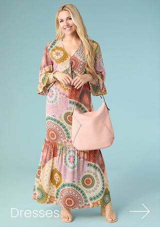 Woman wearing bright printed dress on blue background.